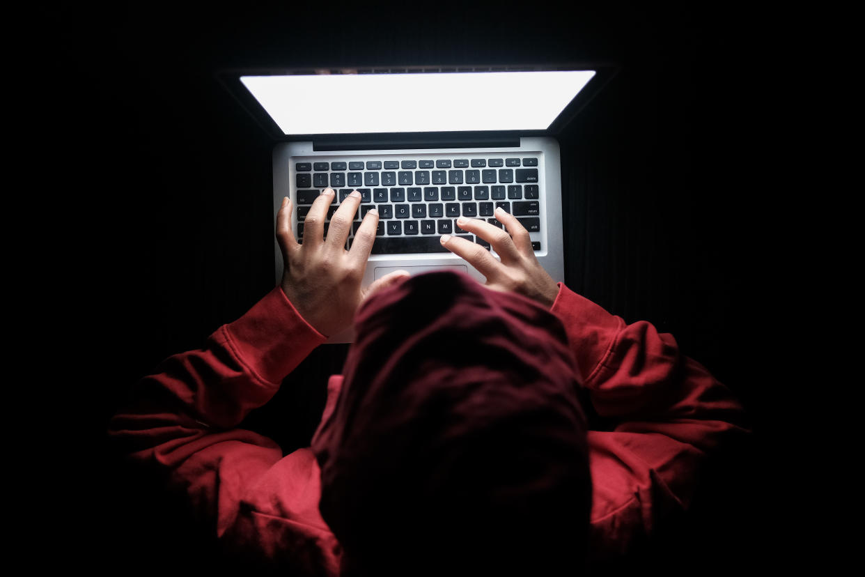 hooded cyber hacker stealing data or information from internet