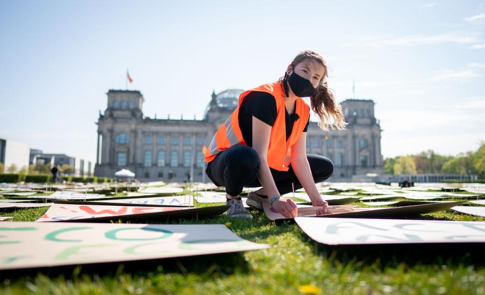 24 April 2020, Berlin: Luisa Neubauer of Fridays for Future lays out protest posters for the alternative climate strike on the Reichstag meadow. Because of the continuing spread of the corona virus, the climate strike is being digitally distributed on the Internet and strikers can participate via the website at www.fridaysforfuture.de/netzstreikfursklima. Photo: Kay Nietfeld/dpa (Photo by Kay Nietfeld/picture alliance via Getty Images)