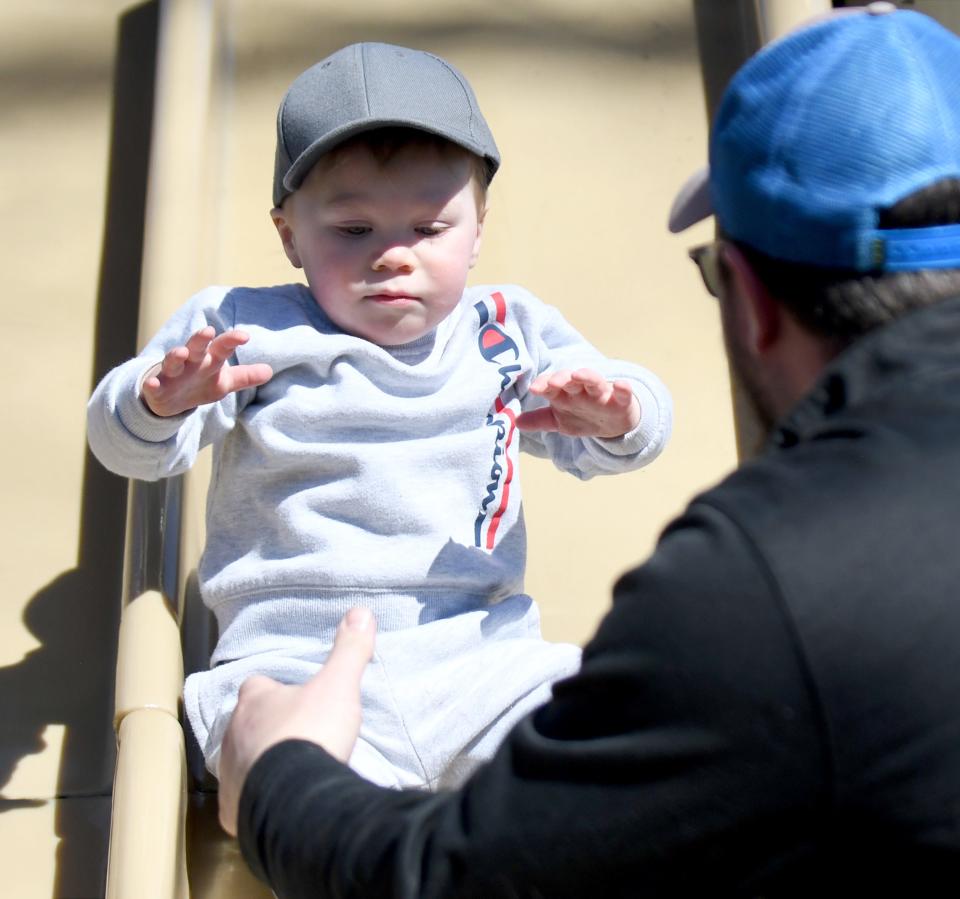 Chase Merten of North Canton catches son Forrest, 2, on the slide last week at Price Park in North Canton.