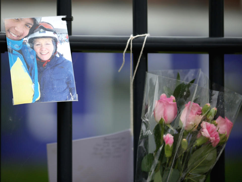 A photograph and flowers hang on the fence outside Corpus Christi Catholic College in tribute to murdered teacher Ann Maguire in Leeds