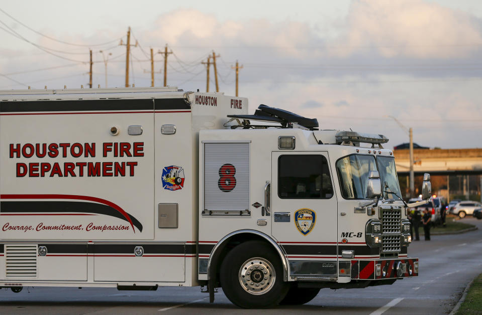 In this Sunday, Dec. 15, 2019 photo, officials respond to the scene of a mercury spill on the intersection of Westview Drive and West Sam Houston Parkway North. A person has been taken into custody for questioning after dozens of people were decontaminated as a precaution due to trace amounts of mercury spilled at three locations in Houston, the FBI said Monday. (Godofredo A. Vásquez/Houston Chronicle via AP)