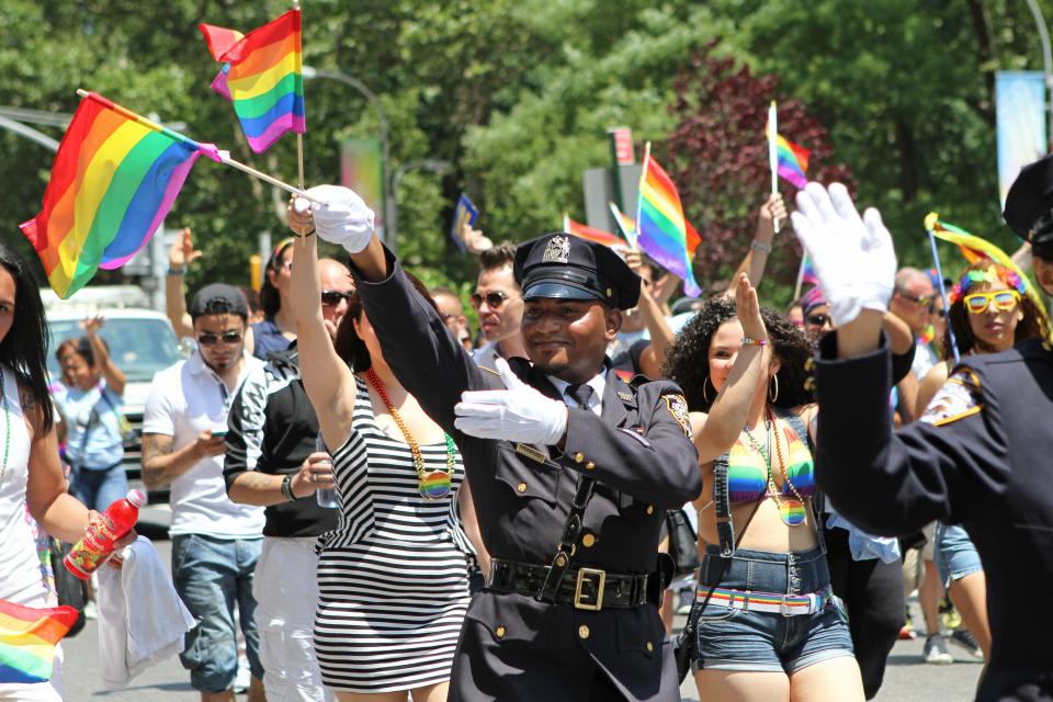 FILE - In this Sunday, June 29, 2014 file photo, NYPD police officers march along Fifth Avenue during the gay pride parade in New York. Organizers of New York City’s Pride events said Saturday, May 15, 2021 they are banning police and other law enforcement from marching in their huge annual parade until at least 2025 and will also seek to keep on-duty officers a block away from the celebration of LGBTQ people and history. (AP Photo/Julia Weeks, File)