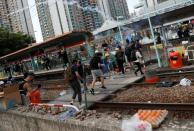 Protesters react after police fired tear gas during a demonstration in support of the city-wide strike and to call for democratic reforms at Tin Shui Wai in Hong Kong