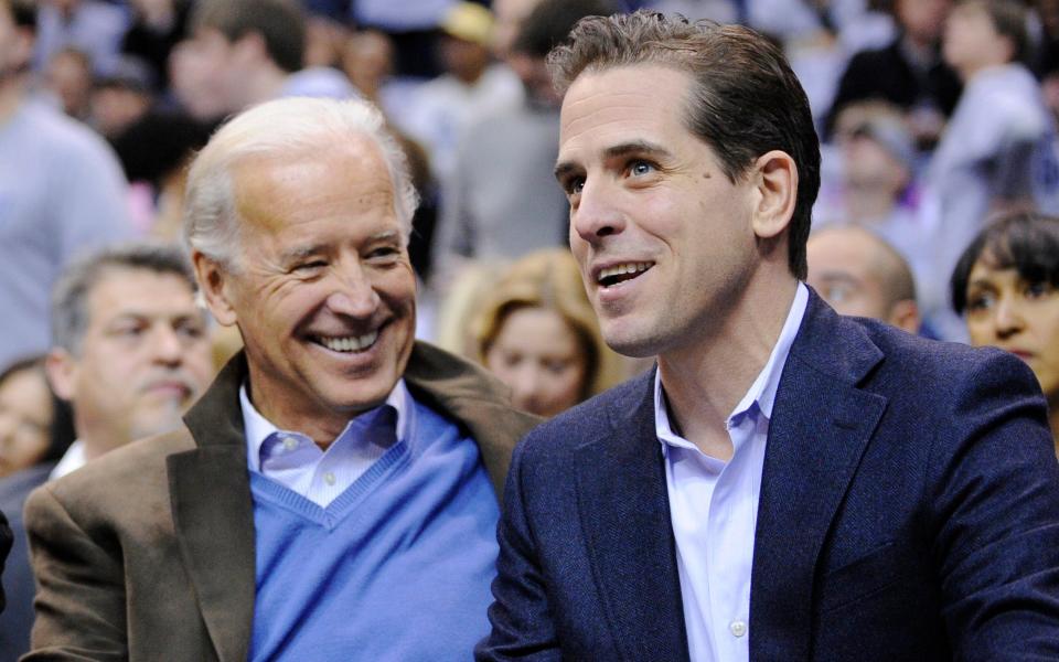 Hunter with his father Joe, then vice-president, at a college basketball game in 2010 - Nick Wass/AP