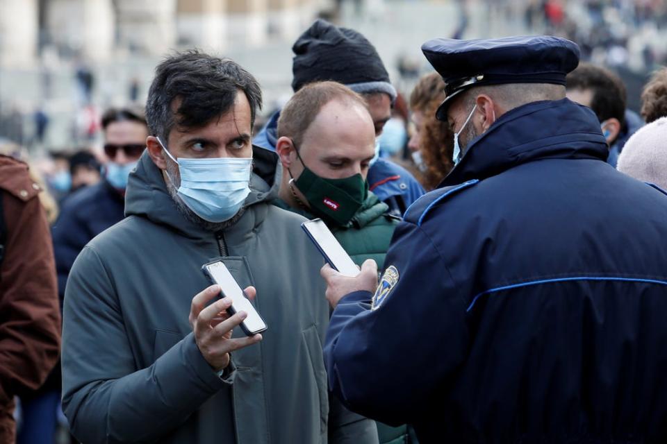 A man has his Covid health pass, known as a Green Pass, checked at the entrance to the Roman Forum  (REUTERS)