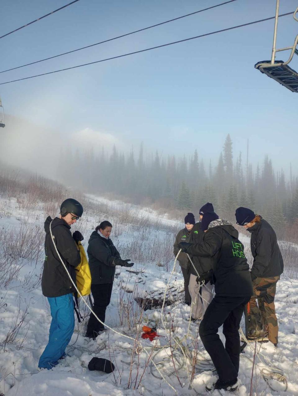 Staff members at Hudson Bay Mountain in Smithers, B.C., gather underneath a chairlift during training on Nov. 25, 2023. The ski hill is waiting for enough snow for it to open for the season. 