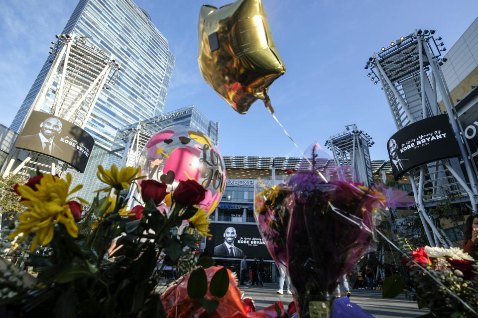 Flowers and balloons are placed at a memorial for Kobe Bryant near Staples Center Monday, Jan. 27, 2020, in Los Angeles. Bryant, the 18-time NBA All-Star who won five championships and became one of the greatest basketball players of his generation during a 20-year career with the Los Angeles Lakers, died in a helicopter crash Sunday. (AP Photo/Ringo H.W. Chiu)