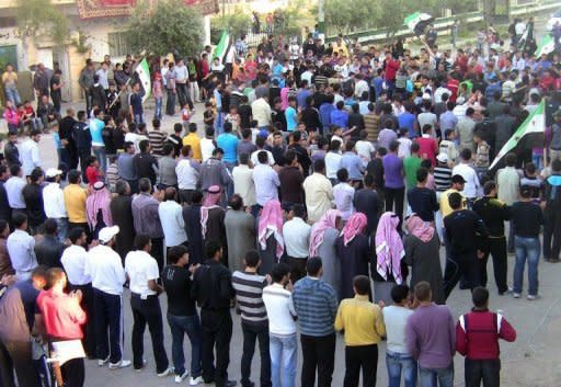 An handout image released by the Syrian opposition's Shaam News Network purportedly shows anti-regime demonstrators waving Syria's pre-Baath former national flag, which has been adopted by the rebels, during a protest against President Bashar al-Assad in Daraa . United Nations ceasefire monitors were touring towns near Damascus, as the European Union slapped new sanctions on the regime