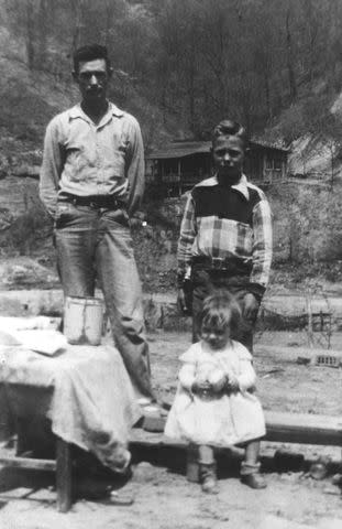 <p>Michael Ochs Archives/Getty </p> Country singer Loretta Lynn's father Melvin "Ted" Webb poses for a portrait with her brother Herman Webb and sister Peggy Sue Webb (Wright) circa 1944 in Butcher Holler, Kentucky.