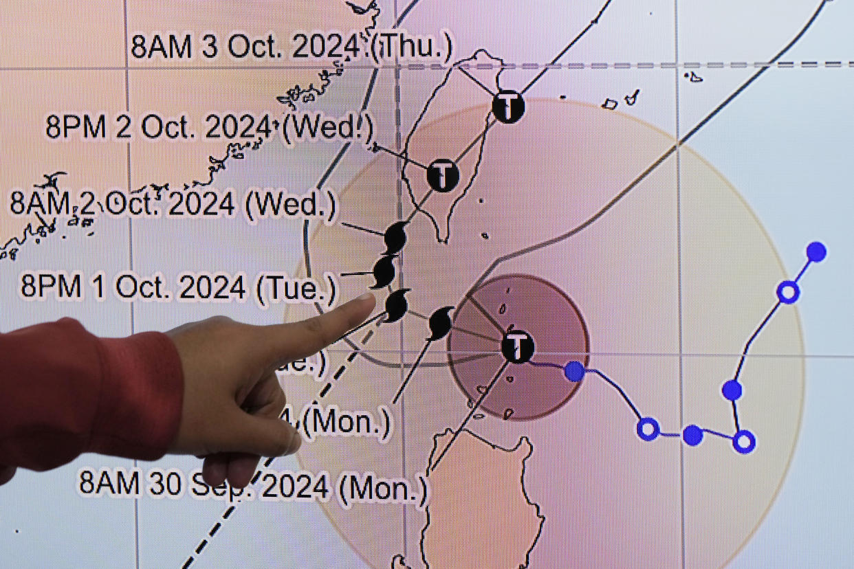 Philippine Atmospheric, Geophysical and Astronomical Services Administration weather specialist Veronica Torres points at the path of powerful Typhoon Krathon on Monday, Sept. 30, 2024, in Quezon city, Philippines as it is projected to go towards Taiwan the next day after hitting northern Philippines. (AP Photo/Aaron Favila)