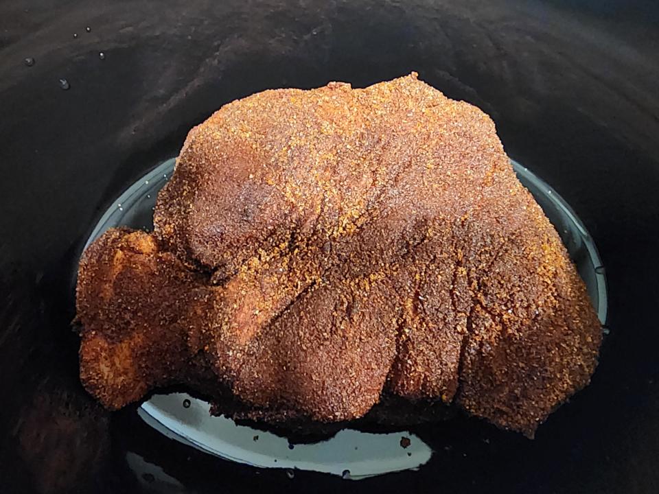 Pork with dry rub in a slow cooker.