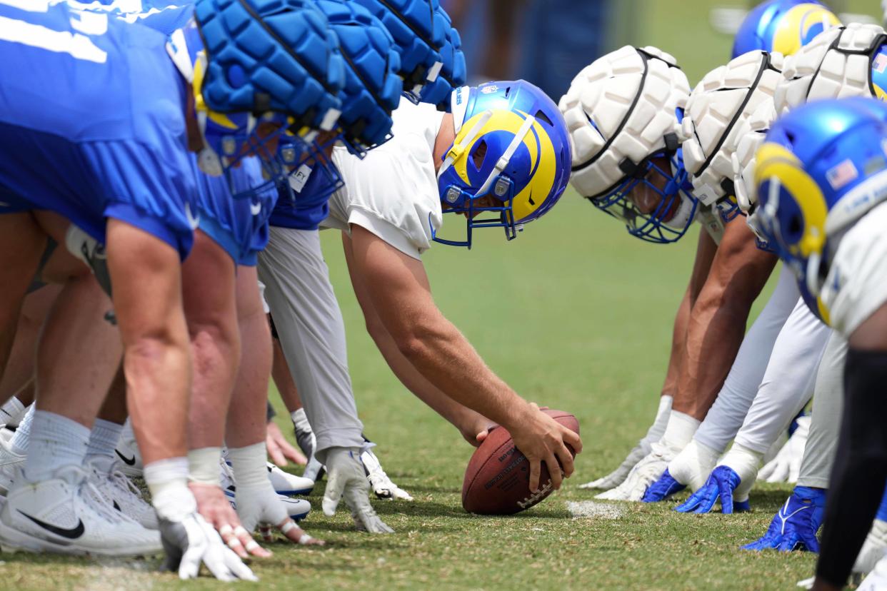 Jun 14, 2023; Thousand Oaks, CA, USA; Los Angeles Rams players wearing Guardian helmet caps at the line of scrimmage as long snapper Alex Ward snaps the ball during minicamp at Cal Lutheran University. Mandatory Credit: Kirby Lee-USA TODAY Sports