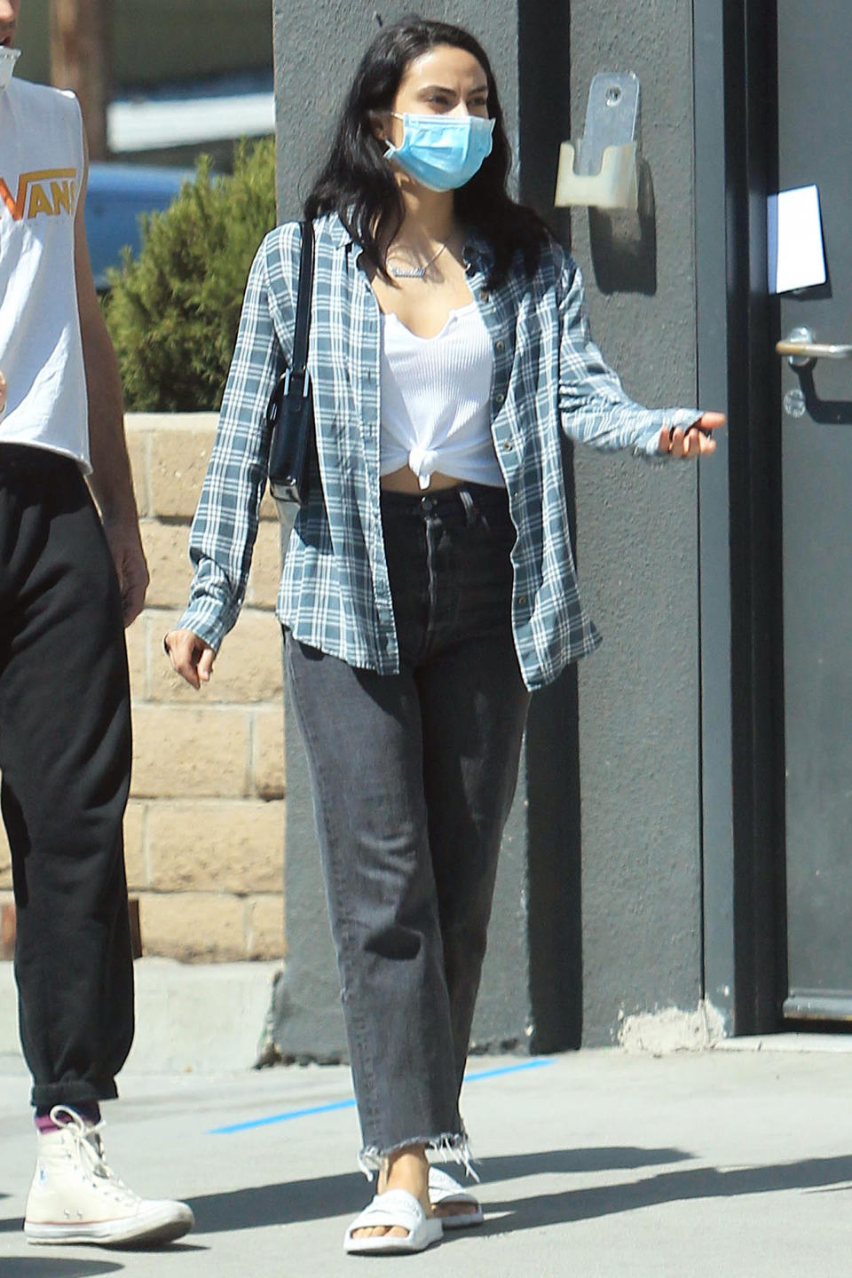 <p>Camila Mendes rocks a flannel and slides on Friday as she makes her way through L.A.</p>