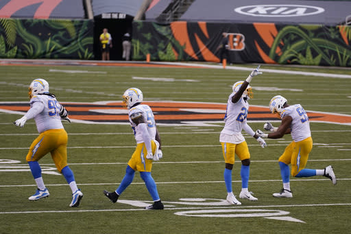 Los Angeles Chargers' Linval Joseph (95), Kenneth Murray (56), Brandon Facyson (28) and Jerry Tillery (99) celebrate after defeating the Cincinnati Bengals an NFL football game, Sunday, Sept. 13, 2020, in Cincinnati. Los Angeles won 16-13. (AP Photo/Bryan Woolston)