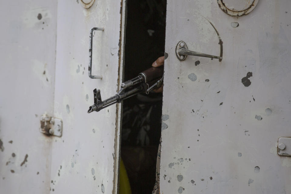 Barrel of a gun belonging to an Indian paramilitary soldier is seen between partially closed doors of an armored vehicle as they drive towards the site of an operation in Awantipora area, south of Srinagar, Indian controlled Kashmir, Wednesday, May 6, 2020. Government forces killed a top rebel commander and his aide in Indian-controlled Kashmir on Wednesday and shut down cellphone and mobile internet services during subsequent anti-India protests, officials, and residents said. (AP Photo/ Dar Yasin)