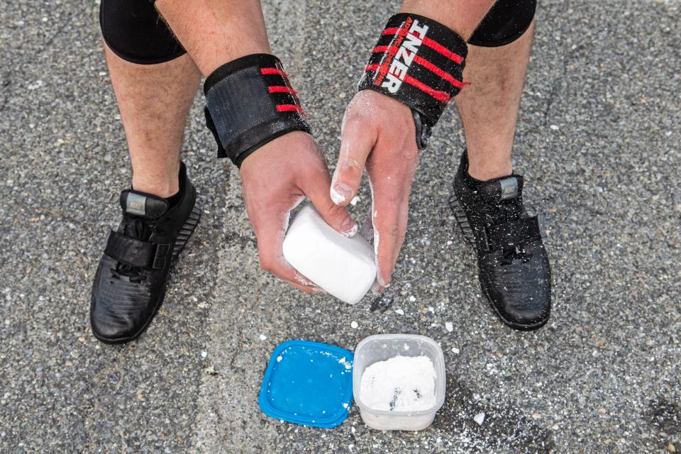 Bradie Crandall chalks his hands before lifting weights at the Training Center near New Castle on Thursday, Aug. 3, 2023. Crandall, a chemical engineering doctoral candidate at the University of Delaware, is among the nation's top powerlifters and a vegan.