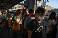 Passengers wearing face masks wait at a bus stop in Metro Manila, Philippines on Sept. 8, 2022. Philippine President Ferdinand Marcos Jr. is extending a state of calamity declared by his predecessor more than two years ago to deal with continuing concerns over the coronavirus pandemic, an official said Monday, Sept. 12, 2022. (AP Photo/Aaron Favila)