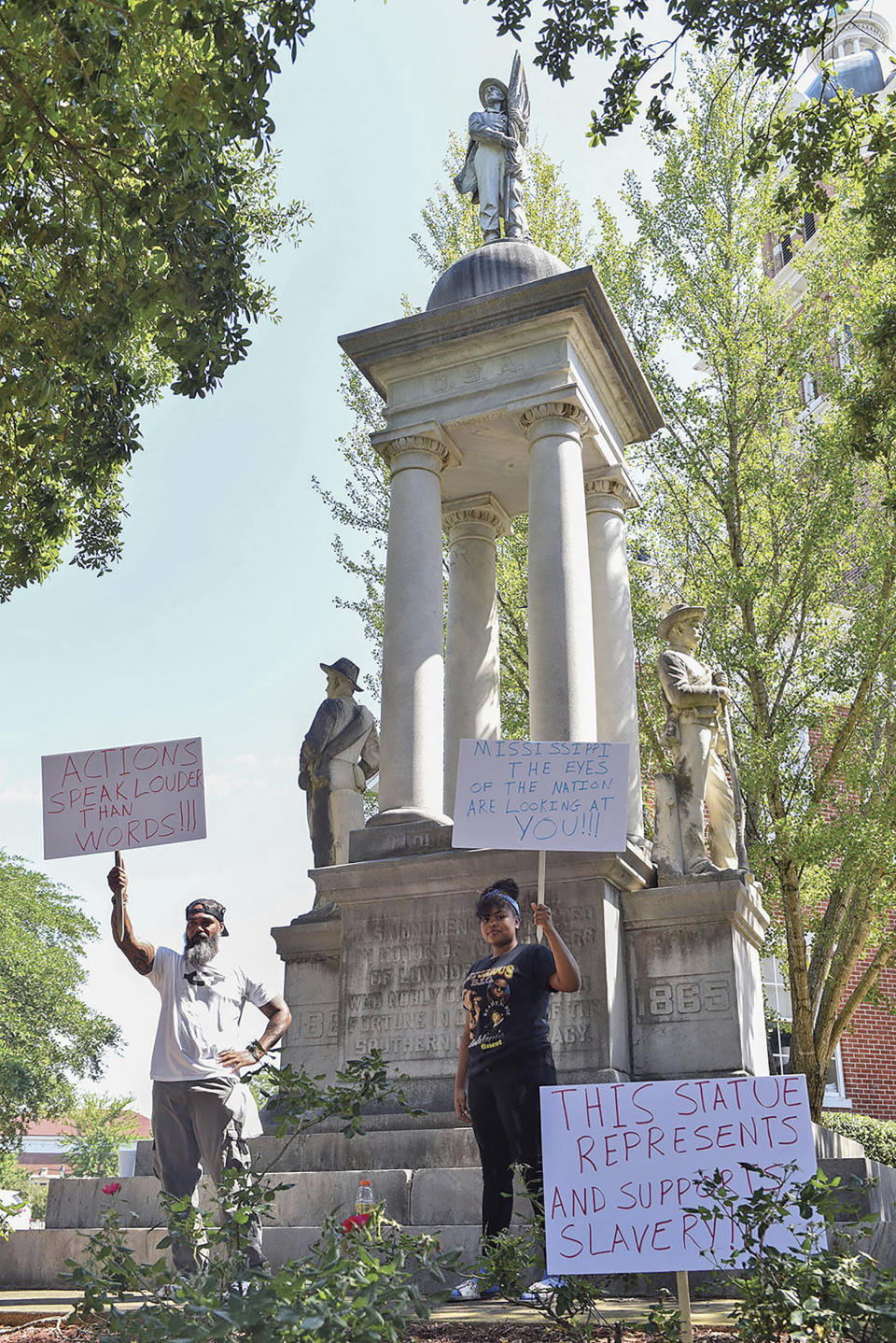 John Lewis, left, and Sonniah Ramirez, 12, protest for the removal of the Confederate monument that stands on the Lowndes County Courthouse lawn, Monday, June 15, 2020 in Columbus, Miss. Lewis was protesting by himself when Ramirez approached him and offered to join in his protest. (Claire Hassler/The Commercial Dispatch, via AP)