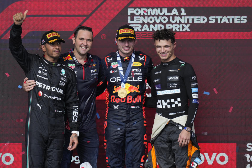 Mercedes driver Lewis Hamilton, of Britain, left, Red Bull driver Max Verstappen, of the Netherlands, second from right, and McLaren driver Lando Norris, of Britain, right, pose for photos on the podium after the Formula One U.S. Grand Prix auto race at Circuit of the Americas, Sunday, Oct. 22, 2023, in Austin, Texas. (AP Photo/Nick Didlick)