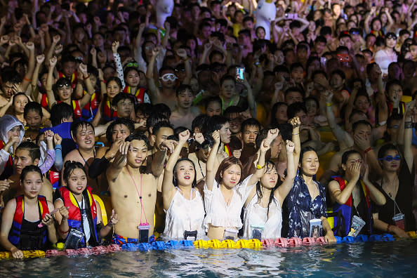 This photo taken shows people watching a performance as they cool off in a swimming pool in Wuhan in China's central Hubei province. 