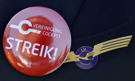 A pilot of German airline Lufthansa, sports a buttons reading "strike" on his uniform as he takes part in a demonstration at Fraport airport in Frankfurt, Germany April 2, 2014. REUTERS/Kai Pfaffenbach/File Photo