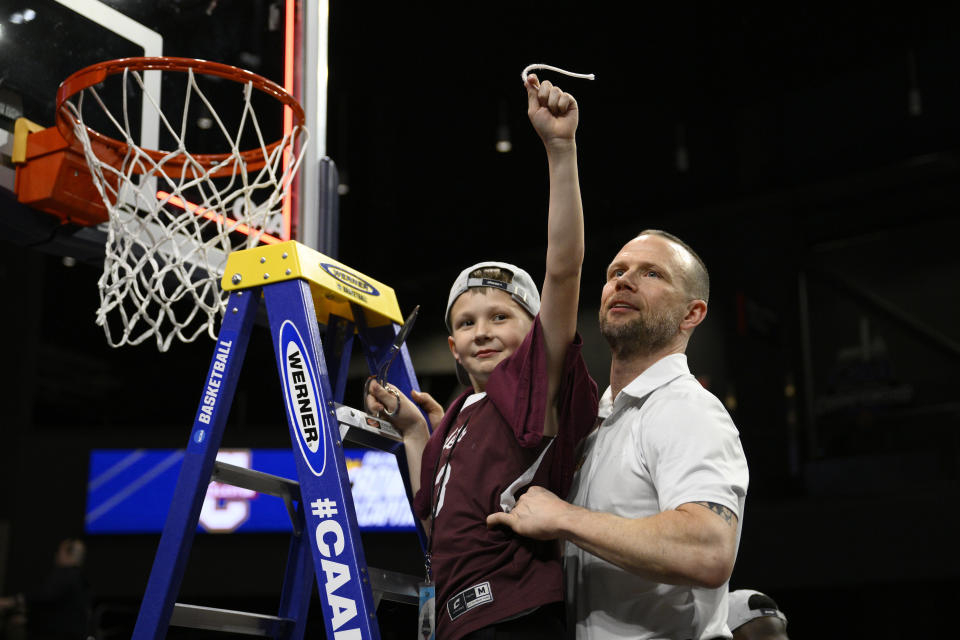 Charleston head coach Pat Kelsey, right, and his son, Johnny, left, stand on the ladder after cutting the net after they won the championship basketball game of the Colonial Athletic Association conference NCAA college basketball tournament against UNC Wilmington, Tuesday, March 7, 2023, in Washington. Charleston won 63-58. (AP Photo/Nick Wass)