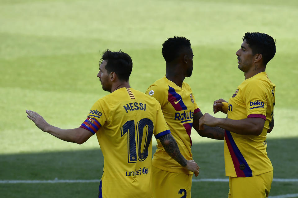 Barcelona's Nelson Semedo, center, celebrates with his teammates Lionel Messi, left, and Luis Suarez, his goal against Alaves during the Spanish La Liga soccer match between Alaves and FC Barcelona, at Mendizorroza stadium, in Vitoria, northern Spain, Sunday, July 19, 2020. (AP Photo/Alvaro Barrientos)