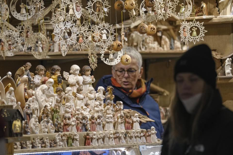 A woman walks by a gift shop at a Christmas market in Vienna, Austria, Saturday, Nov. 20, 2021. The Austrian government announced a nationwide lockdown that will start Monday and comes as average daily deaths have tripled in recent weeks and hospitals in heavily hit states have warned that intensive care units are reaching capacity. (AP Photo/Vadim Ghirda)