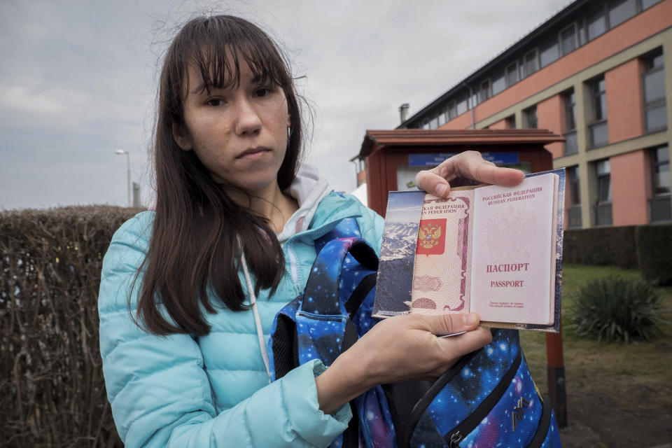 Olena, a Russian citizen fleeing from Kyiv, Ukraine (no family name given for safety reson) shows her Russian passport after arriving at the outskirt of Budapest, Hungary on Friday, March. 4, 2022. Olena who years ago left her home country in opposition to Vladimir Putin's government has been forced to flee again — this time from her adopted home of Kyiv — as Putin's armed forces assault Ukraine. (AP Photo/Balazs Kaufmann)