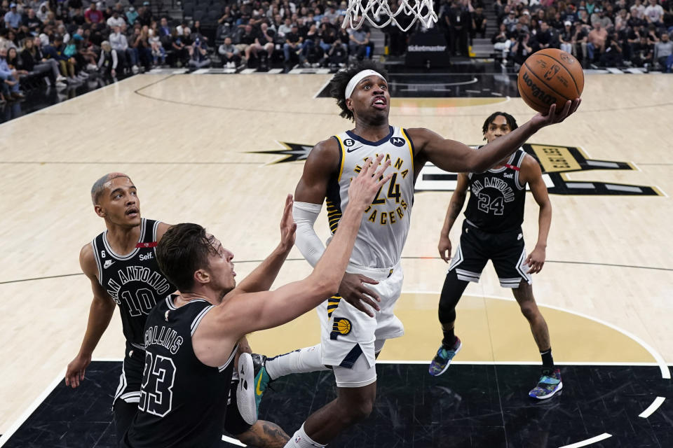 Indiana Pacers guard Buddy Hield (24) drives to the basket past San Antonio Spurs forward Zach Collins (23) during the first half of an NBA basketball game in San Antonio, Thursday, March 2, 2023. (AP Photo/Eric Gay)