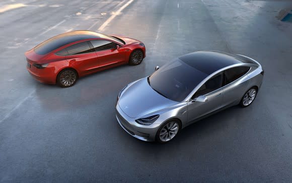 Overhead views of silver and red Tesla Model 3 sedans