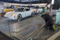 Workers dismantle a booth after that the 90th Geneva International Motor Show (GIMS) is cancelled by Swiss authorities, at the Palexpo in Geneva, Switzerland, Friday, Feb. 28, 2020. The 90th edition of the International Motor Show, scheduled to begin on March 5th, is cancelled due to the advancement of the (Covid-19) coronavirus in Switzerland. The Swiss confederation announced today that all events involving more than 1,000 people would be banned until 15 March. (KEYSTONE/Salvatore di Nolfi)