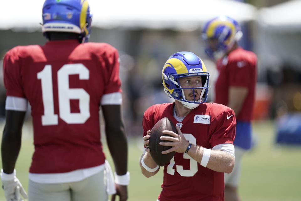 Rams quarterback John Wolford takes part in drills as Bryce Perkins (16) watches.