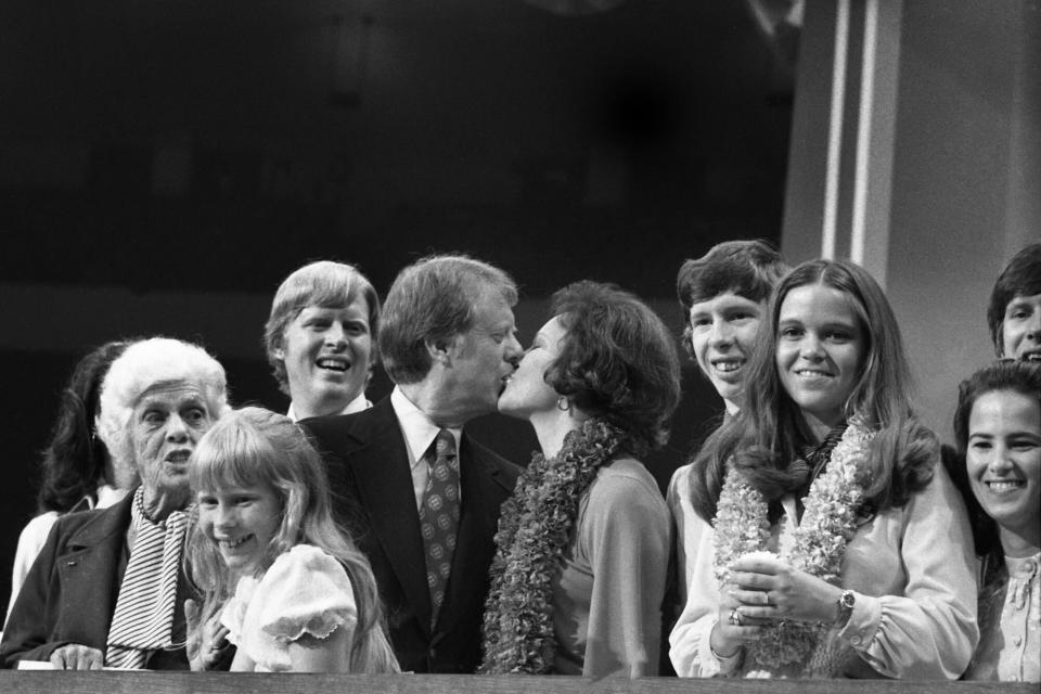 The new "first family" of the Democratic Party gathers on the podium at the Democratic National Convention. From left: Lillian Carter, mother; Amy, daughter; Jack, son; Jimmy Carter kissing wife, Rosalynn; Jeff, son and his wife, Annette. It was a triumphant night for the family from Plains, Georgia. (Photo by Bettmann Archive/Getty Images)