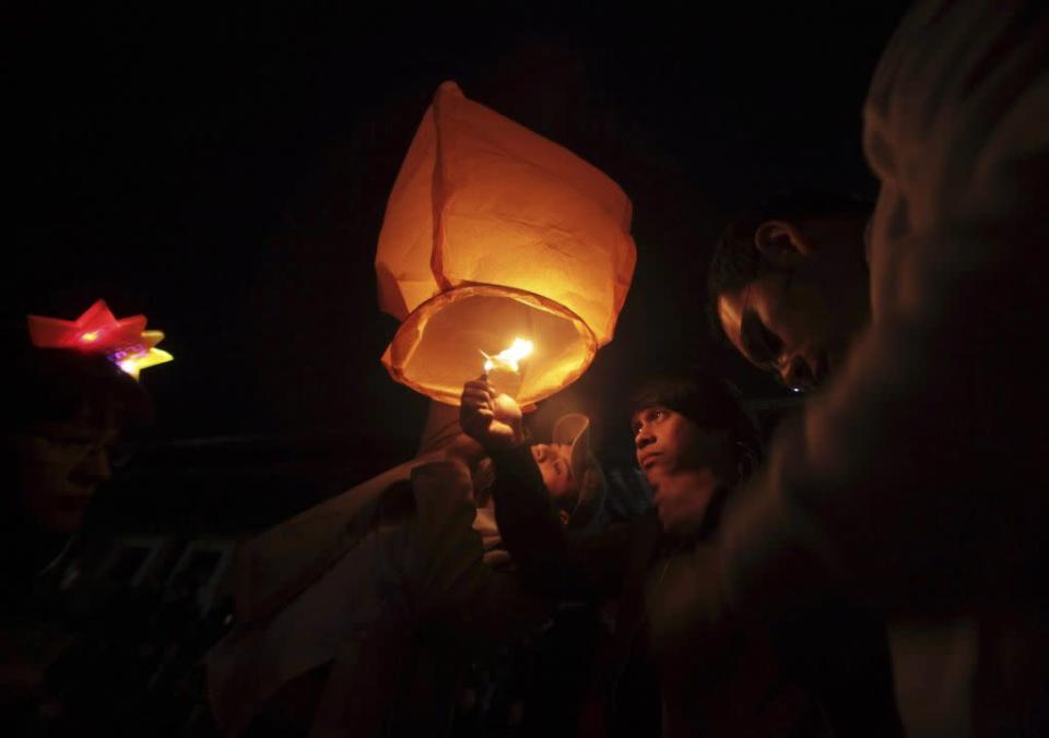 Revellers launch a floating paper lantern into the sky as they celebrate New Year's Day in Antigua, 60 km (37 miles) from Guatemala City, January 1, 2013.