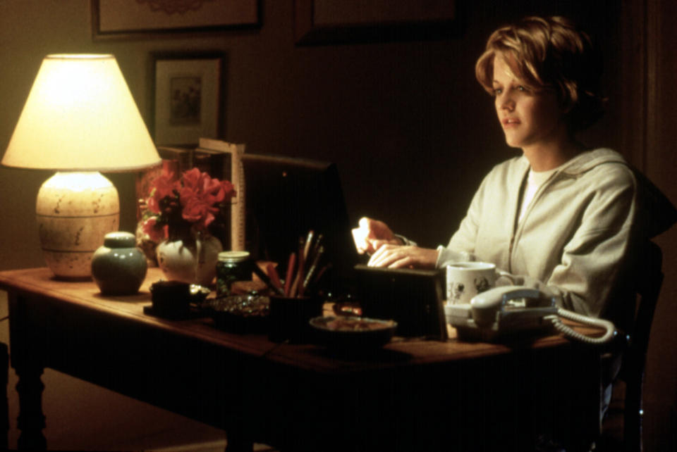 Meg Ryan sitting at a desk in You've Got Mail