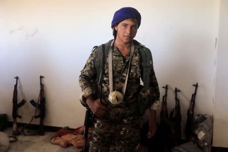 Kahran, 17, a member of the Syrian Democratic Forces is pictured with his homemade grenade during fighting with Islamic state in Al Senaa, a district of Raqqa, Syria, August 10, 2017. REUTERS/Zohra Bensemra