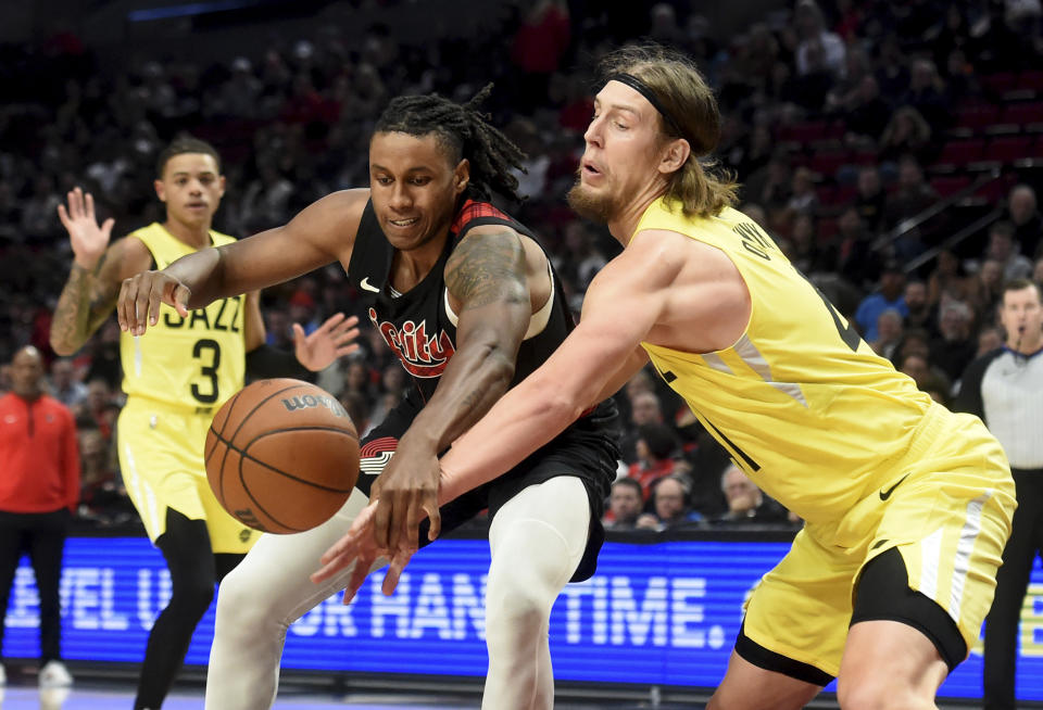 Portland Trail Blazers forward Jabari Walker, left, and Utah Jazz forward Kelly Olynyk, right, go after a loose ball during the first half of an NBA basketball game in Portland, Ore., Wednesday, Nov. 22, 2023. (AP Photo/Steve Dykes)