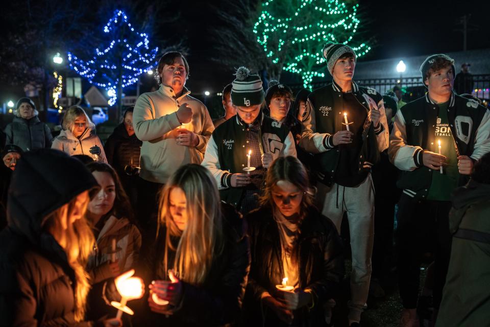 People stand with lit candles during a candlelight vigil at Children's Park in Lake Orion on Thursday, December 2, 2021, while showing support for neighboring village of Oxford after an active shooter situation at Oxford High School that left four students dead and multiple others with injuries. 