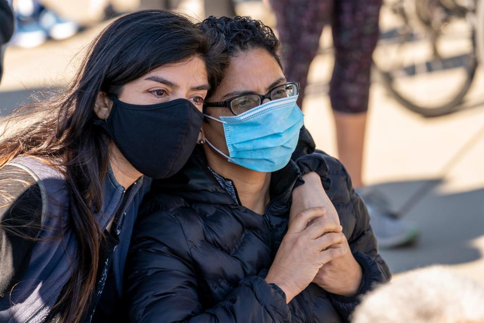 As people gather at the Supreme Court on the day after the death of Justice Ruth Bader Ginsburg, Rosio Marin of Washington, left, comforts a close friend who declined to give her name, as they mourn the loss of one of the court's liberal justices, Saturday, Sept. 19, 2020 in Washington.