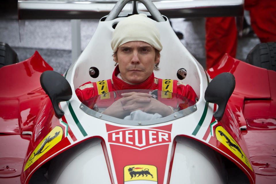 Daniel Brühl as Niki Lauda as he sits in a red Formula One vehicle