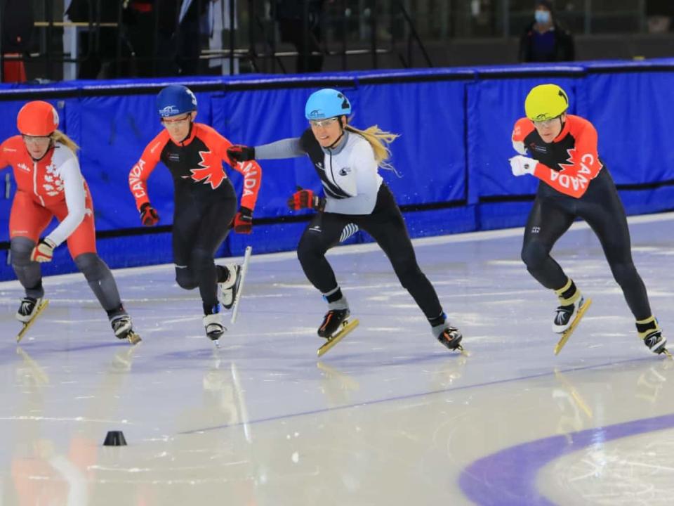 Alison Anderson, in the yellow helmet, at the start of a speed skating race at the Masters International Short Track Games in March 2022. Anderson set four world records in her age category, 30-34, at the games. (Submitted by Alison Anderson - image credit)