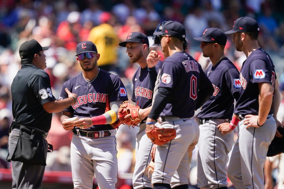 Cleveland Guardians starting pitcher Tanner Bibee, third from left, argues with an umpire, left, after Los Angeles Angels' Kyren Paris (not shown) advanced to third on a balk call during the third inning of a baseball game, Sunday, Sept. 10, 2023, in Anaheim, Calif. (AP Photo/Ryan Sun)