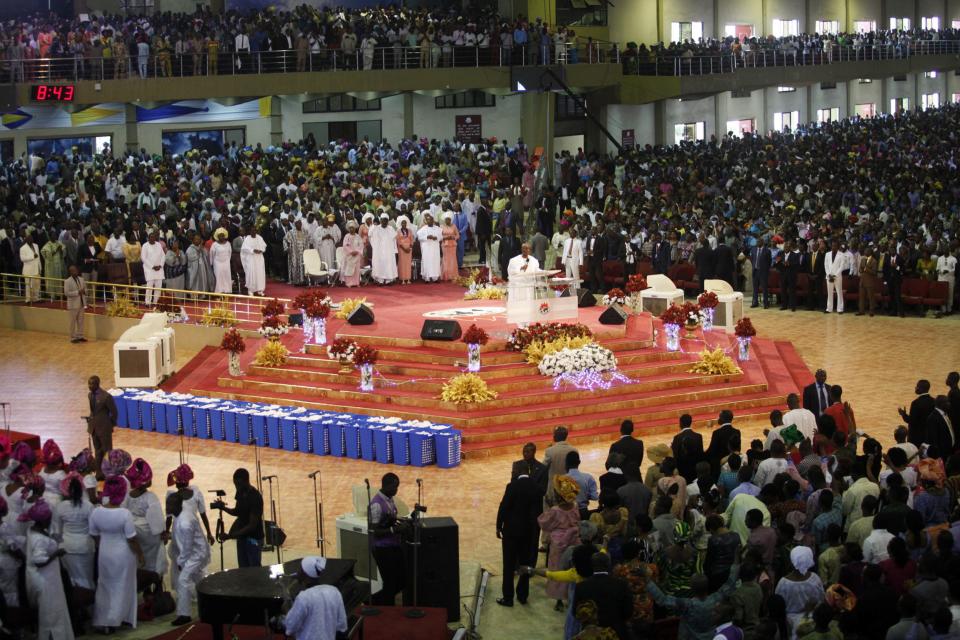 Bishop David Oyedepo (C), founder of the Living Faith Church, also known as the Winners' Chapel, conducts a service for worshippers in the auditorium of the church in Ota district, Ogun state, some 60 km (37 miles) outside Nigeria's commercial capital Lagos September 28, 2014. Hundreds of millions of dollars change hands each year in Nigeria's popular Pentecostal "megachurches", which are modelled on their counterparts in the United States. Some of these churches can hold more than 200,000 worshippers and, with their attendant business empires, they constitute a significant section of the economy, employing tens of thousands of people and raking in tourist dollars, as well as exporting Christianity globally. To match Insight NIGERIA-MEGACHURCHES/ Picture taken September 28, 2014. REUTERS/Akintunde Akinleye (NIGERIA - Tags: RELIGION BUSINESS)