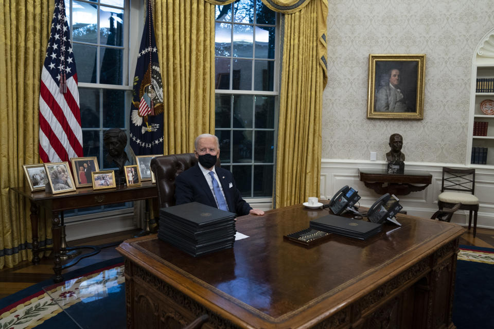 President Joe Biden signs a series of executive orders in the Oval Office of the White House, Wednesday, Jan. 20, 2021, in Washington. (AP Photo/Evan Vucci)