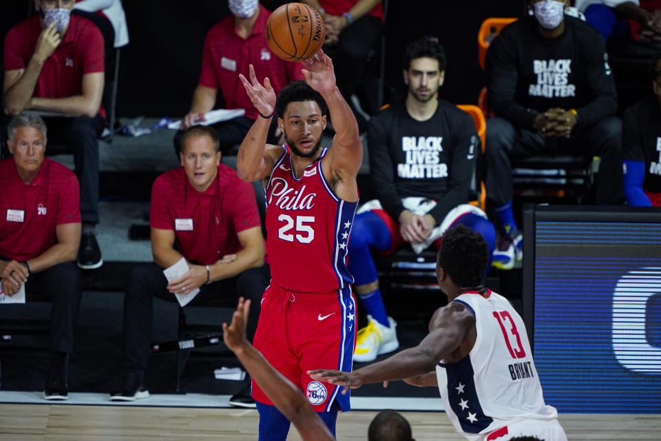 Philadelphia 76ers guard Ben Simmons (25) shoots over Washington Wizards center Thomas Bryant (13) during the second half of an NBA basketball game Wednesday, Aug. 5, 2020 in Lake Buena Vista, Fla. (AP Photo/Ashley Landis)