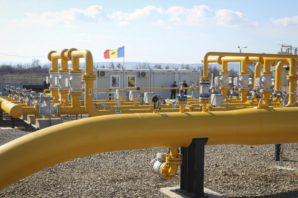 Men stand next to pipelines of the national natural gas distribution network outside Ungheni, Moldova, March 4, 2015. The country faces a looming natural gas supply shortage this winter after it failed to renew a long-term contract with Russia, as on Tuesday, Oct. 26, 2021, the former Soviet republic received a million cubic meters of gas from Poland, the first time in history it has turned to a non-Russian supplier, amid increasing geopolitical tensions as Moldova looks to forge closer ties with the European Union after for years being under strong Russian influence.(AP Photo/Aurel Obreja)