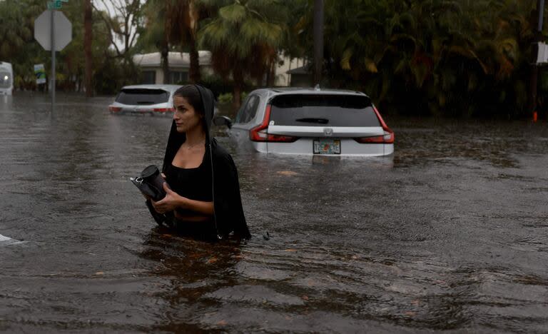 Una persona camina por una calle inundada el 12 de junio de 2024, en Hollywood, Florida. Con el paso de la humedad tropical, algunas zonas se han inundado debido a las fuertes lluvias. 