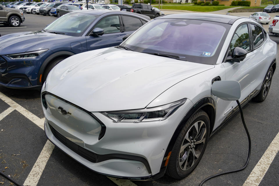 In this photo made on Thursday, May 6, 2021, a pair of 2021 Ford Mustang Mach E are seen at a Ford dealer in Wexford, Pa.  Ford is spinning off its electric vehicles and internal combustion businesses into separate units. The automaker said Wednesday, March 2, 2022 that its plan includes two distinct, but strategically interdependent, auto businesses &#x002013; Ford Blue and Ford Model e.   (AP Photo/Keith Srakocic)