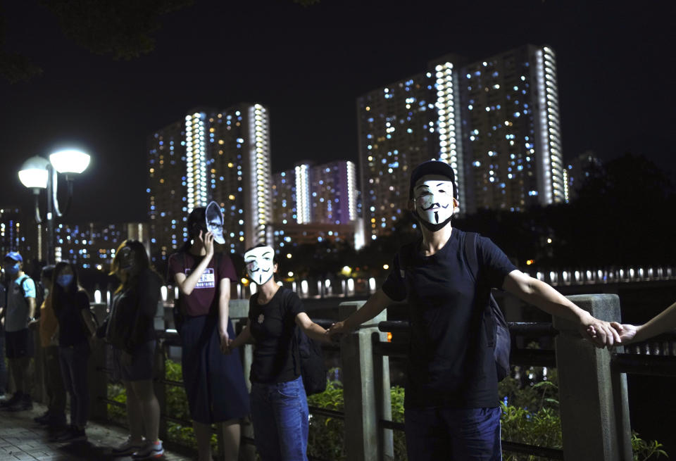 Protesters wear masks in Hong Kong, Friday, Oct. 18, 2019. Hong Kong pro-democracy protesters are donning cartoon/superhero masks as they formed a human chain across the semiautonomous Chinese city, in defiance of a government ban on face coverings. (AP Photo/Vincent Yu)